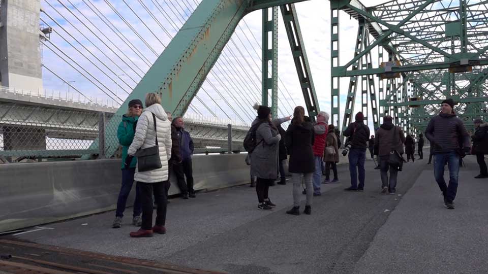 Des participants à des visites guidées marchent sous la structure d’acier du pont Champlain à Montréal. (photo : François Séguin)