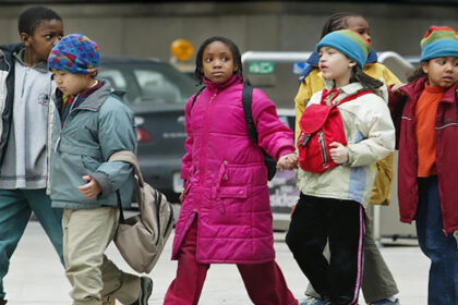 Enfants issus de l’immigration marchant vers l’école au Québec, symbole des défis d’intégration et du manque d’encadrement dans le système d’éducation québécois.