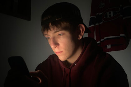 Un jeune Québécois consulte des plateformes de paris sportifs, un phénomène amplifié par les influenceurs et réseaux sociaux.