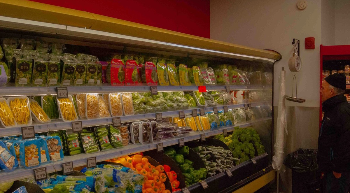 Photo d'un homme qui décide quels légumes acheter dans l'épicerie indépendante Supermarché PA