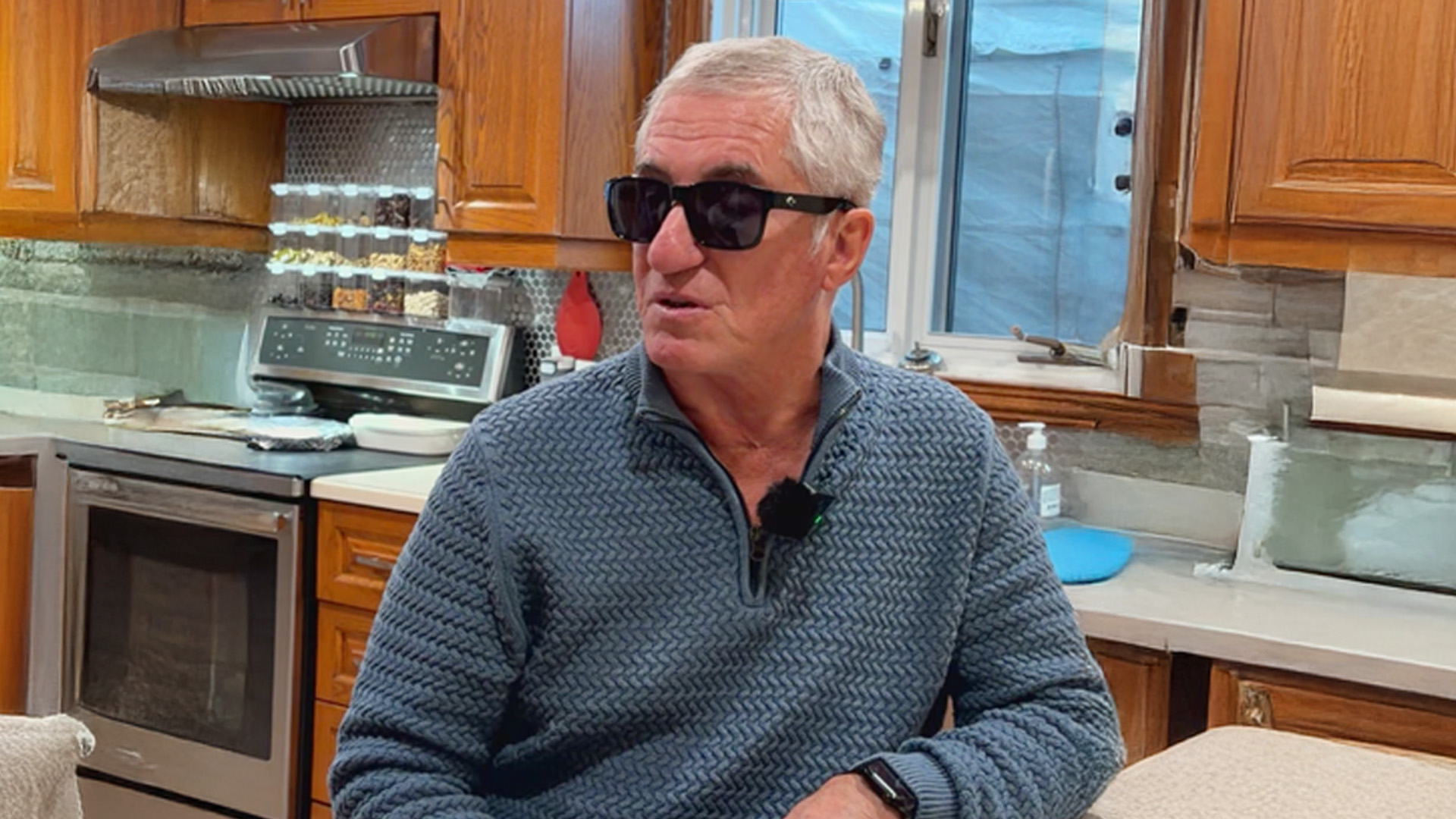 Claude, 72 ans, dans sa cuisine, portant les lunettes intelligentes Meta d’Oakley.