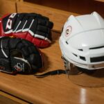 Un casque et des gants de hockey déposés sur un banc