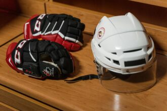 Un casque et des gants de hockey déposés sur un banc