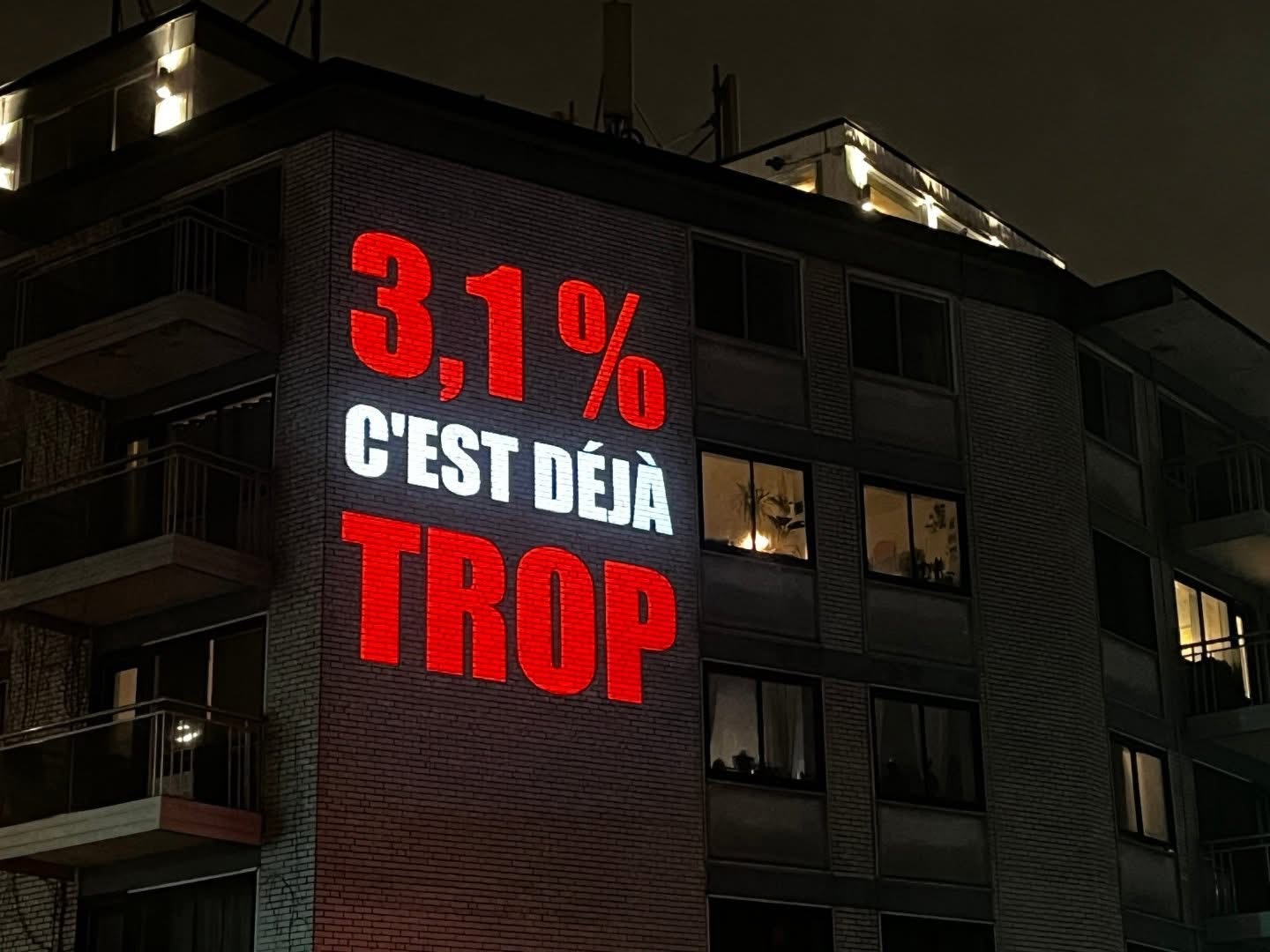 « 3,1% c’est déjà trop » est projeté sur un immeuble de Parc Extension