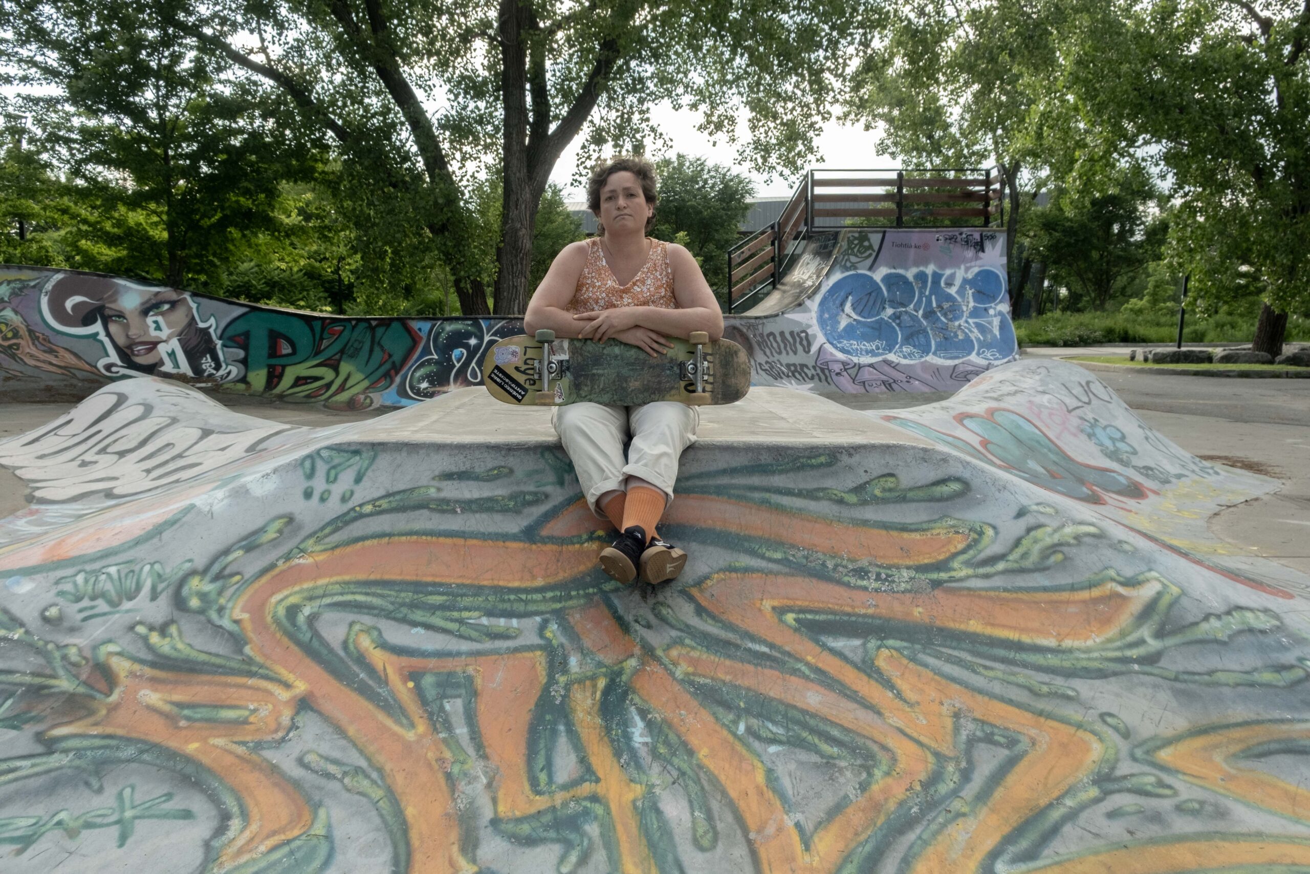 Frédérique Luyet, skateboardeuse et bénévole au skatepark Projet 45 pose entre les modules avec sa planche.